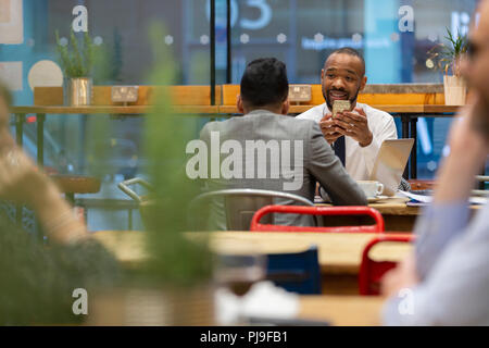 Businessmen with smart phone working in cafe Stock Photo
