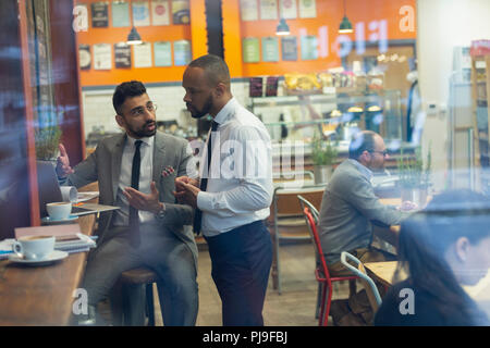 Businessmen using laptop, working in cafe Stock Photo