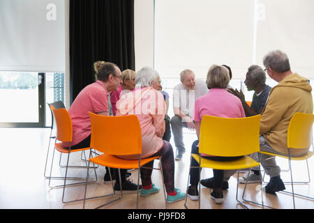 Active seniors talking in circle in community center Stock Photo