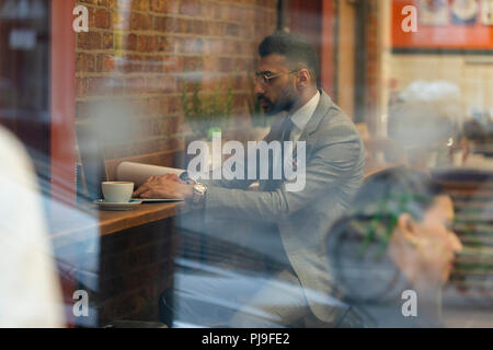 Businessman working at laptop in cafe Stock Photo