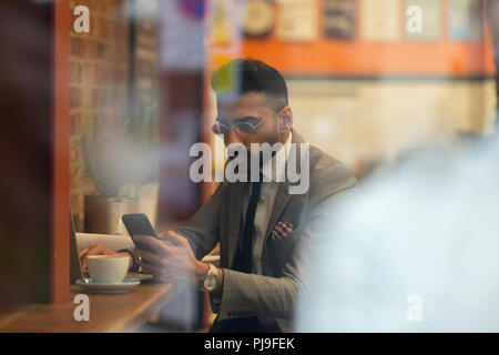 Businessman using smart phone, working in cafe Stock Photo