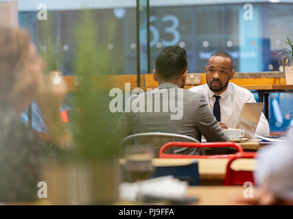 Businessmen talking, working in cafe Stock Photo