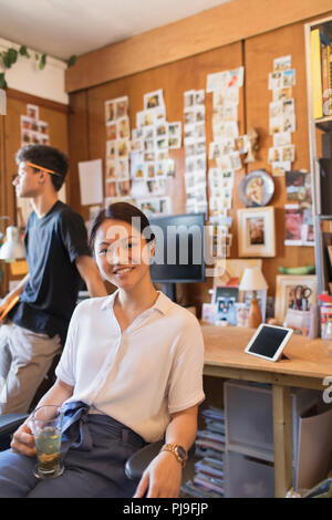 Portrait smiling, confident creative businesswoman drinking tea in office Stock Photo