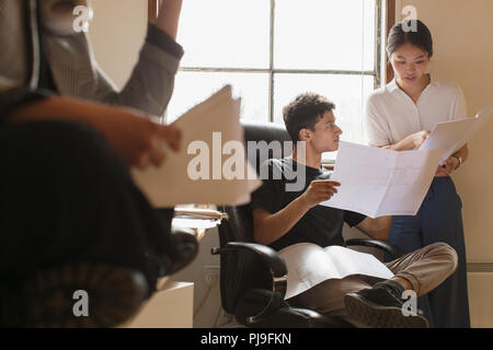 Architects reviewing blueprints in office Stock Photo