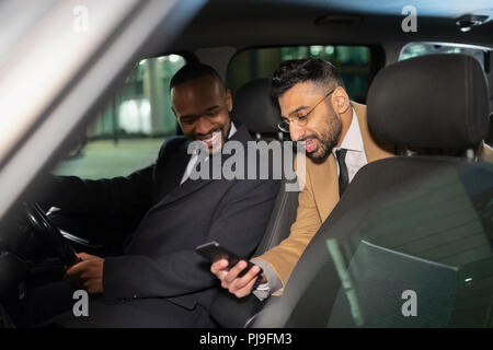 Businessman with smart phone using crowdsourced taxi Stock Photo