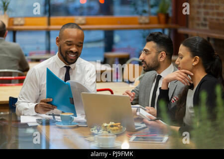 Business people discussing paperwork, working in cafe Stock Photo