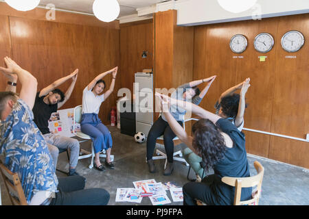 Creative business people stretching, taking a break in meeting Stock Photo