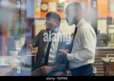 Businessmen working at laptop in cafe Stock Photo