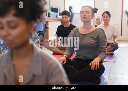 Serene creative businesswoman meditating in office Stock Photo