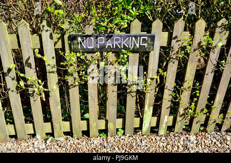 No Parking sign on a garden fence next to a roadLoose Village, Maidstone, Kent, UK. Stock Photo