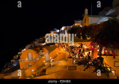 Restaurants at the famous Oia village on Santorini island at sunset, Greek Cyclades islands, Santorini, Greece. Stock Photo