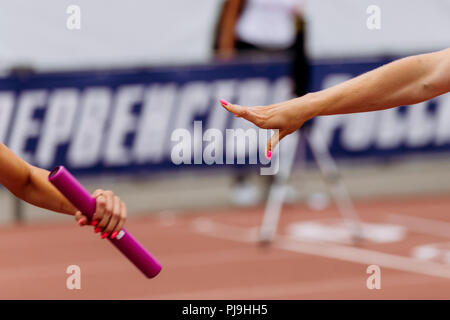 hands women runners passing baton in relay race Stock Photo