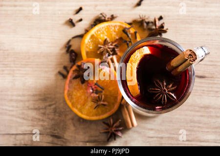 Mulled wine in glass with spice and fruit on wooden table. Top view. Copyspace Stock Photo