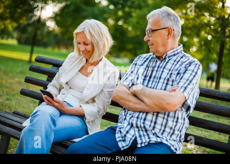 Senior man is angry while his woman is messaging on phone. Stock Photo