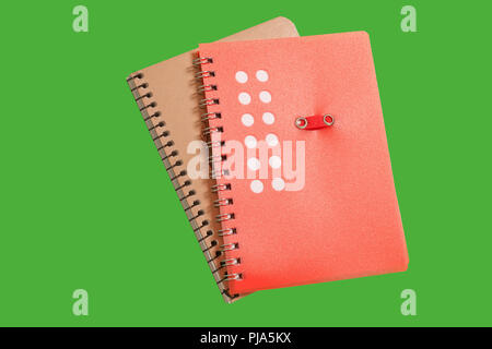 two spiral notebooks on a green surface Stock Photo