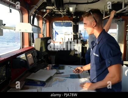 U.S. Coast Guard Cadet Chip Crowley plots a position fix on the bridge of the Coast Guard Cutter Joseph Gerczak (WPC 1126) near Waikiki, July 4, 2018. The Joseph Gerczak crew took part in a Fourth of July security operation to ensure the safety of swimmers in the water. (United States Coast Guard Stock Photo