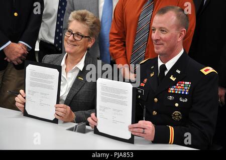 Dr. Emily Allen, dean of the College of Engineering, Computer Science and Technology, California State University, Los Angeles, and Col. Kirk Gibbs, commander of the U.S. Army Corps of Engineers Los Angeles District, sign a partnering agreement July 5 in Los Angeles, California, to foster collaboration in a relationship that stresses the importance of Science, Technology, Engineering and Mathematics as officials from the university and the Corps look on. The agreement also provides a road map to employment with the Corps through various programs, including the Pathways internship program. Stock Photo