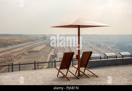 05 September 2018, Germany, Elsdorf: On the Terra Nova viewing platform, with a view of the Hambach open-cast lignite mine, there are two deck chairs with parasols. Photo: Christophe Gateau/dpa Stock Photo