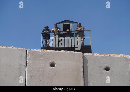 Rosh Hanikra, ISRAEL. 5th September, 2018. Members of the Lebanese Armed Forces stand outside a watchtower as they look down from the Lebanese side of the border along a seven-meter high security wall built by Israel on the Israeli-Lebanese border near Rosh HaNikra Crossing also known as Ras Al Naqoura Crossing. The concrete wall stretches  from the Mediterranean Sea in the west to the area around Mount Hermon in the east. Stock Photo