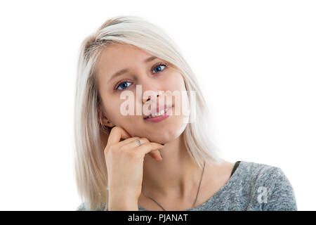 Cute young female with charming blue eyes and broad smile thoughtful  holding hand under her chin having clever expression looking sincerely into came Stock Photo
