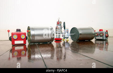 concept phone line being cut of with retro robots on a wooden floor Stock Photo