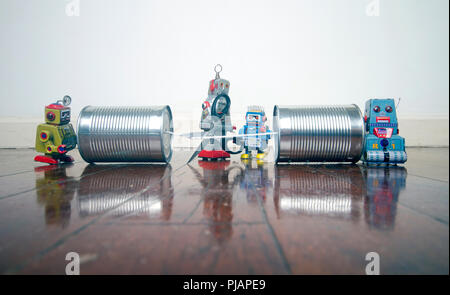 concept phone line being cut of with retro robots on a wooden floor Stock Photo