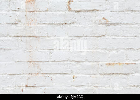 Closeup of old brick wall painted white and distressed, peeling and stained. Ideal for grunge background texture Stock Photo