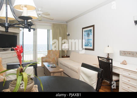A tastefully decorated living room with a patio door overlooking the ocean. Stock Photo