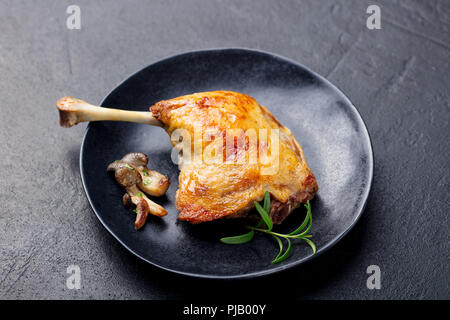 Duck legs confit with mushroom sauce . Restaurant serving. Close up. Stock Photo