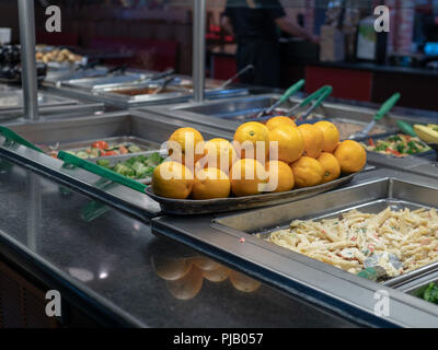 Oranges piled on a buffet table with various pastas  Stock Photo