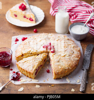 Almond and raspberry cake, Bakewell tart. Traditional British pastry. Wooden background. Stock Photo