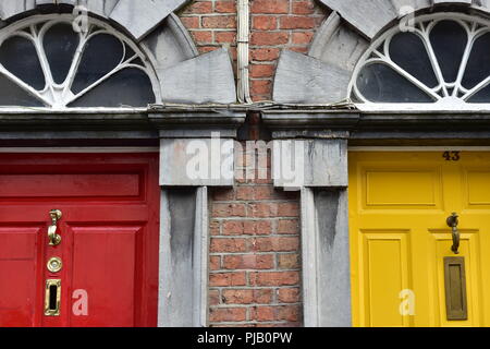 Typical wooden doors with colorful paint on English brick townhouse. Stock Photo