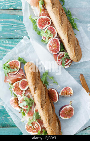 Top view sandwich with prosciutto, mascarpone cheese and figs on wooden table Stock Photo