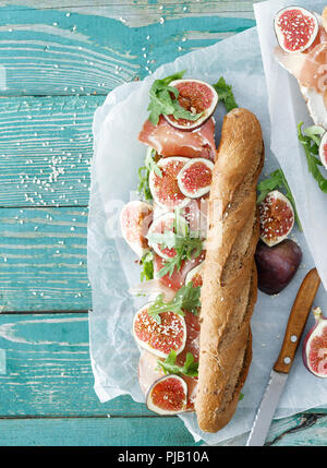 Sandwich with prosciutto, mascarpone cheese and figs on wooden table with copy space top view Stock Photo