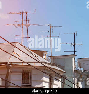 TV Antenna on the roof of the house against blue sky Stock Photo