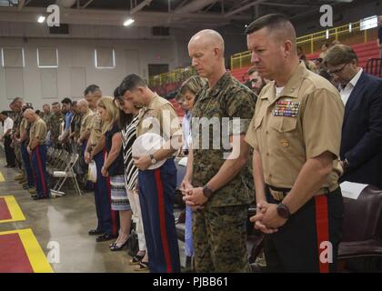 U.S. Marines and their families bow their heads during the invocation at the 6th Marine Corps District (MCD) change of command ceremony at Parris Island, South Carolina, July 2, 2018. During the ceremony, Col. Jeffrey C. Smitherman, the outgoing Commanding Officer of 6th MCD, relinquished his command to Col. William C. Gray. Stock Photo