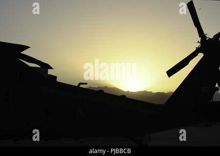 The sun rises over the mountains in eastern Afghanistan shedding light on a UH-60 Blackhawk helicopter assigned to Task Force Shadow at Bagram Airfield July 2. Stock Photo