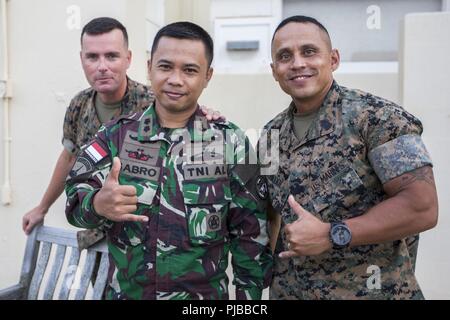MARINE CORPS BASE HAWAII (July 2, 2018) U.S. Marine Corps Sgt. Maj. Phillip Billiot, left, sergeant major, 3rd Marine Regiment, Indonesian Navy Lt. Cmdr. Sabro, and Sgt. Maj. Charlie Wells, sergeant major, Marine Corps Base Hawaii (MCBH), pose for a photo during a Marine Air-Ground Task Force (MAGTF) Hawaii social event as part of Rim of the Pacific (RIMPAC) exercise at MCBH July 2, 2018. MCBH senior leadership invited RIMPAC participants and community leaders to a dinner at the Officer’s Club. RIMPAC provides high-value training for task-organized, highly-capable MAGTF and enhances the critic Stock Photo