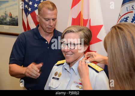 Rear Adm. Joanna Nunan, the Ninth District Commander, has her shoulder boards replaced by her husband and daughter during a promotion ceremony July 3, 2018 in Cleveland. Nunan was advanced from Rear Adm. Lower Half to Rear Adm. Upper Half. Stock Photo