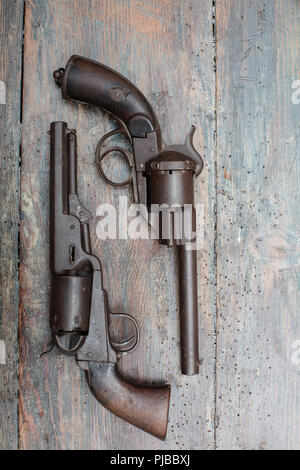 High resolution image of historical guns and pistols on a vintage wood background in an exhibit in a museum or collectors showcase Stock Photo