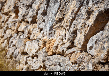 Old wall made of volcanic rough rocks, shallow depth of field. Stock Photo