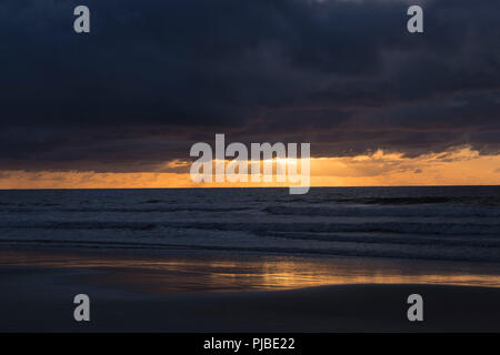 A storm rolling in over the ocean with sun breaking through. Stock Photo