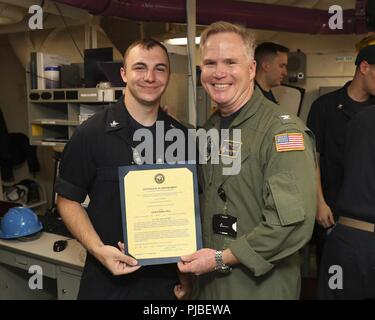 NORFOLK, Va. (July 10, 2018) Electrician’s Mate (Nuclear) 2nd Class Lucas Bilodeau, from Hartford, Connecticut, assigned to USS Gerald R. Ford’s (CVN 78) reactor department, receives his certificate of appointment to the rank of petty officer second class from Capt. Richard McCormack, Ford’s commanding officer. Bilodeau was promoted following his selection for the Meritorious Advancement Program. Stock Photo