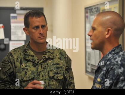 MARINE CORPS BASE HAWAII (July 11, 2018) — Rear Adm. John Okon, Commander, Naval Meteorology and Oceanography (METOC) Command, speaks with Lt. Christopher Wilson, Commander, Task Force 172 Staff METOC Officer, during a tour of Tactical Operations Center, Marine Corps Base Hawaii during Rim of the Pacific (RIMPAC) exercise, July 11. Twenty-five nations, 49 ships, six submarines, about 200 aircraft, and 25,000 personnel are participating in RIMPAC from June 27 to Aug. 2 in and around the Hawaiian Islands and Southern California. The world’s largest international maritime exercise, RIMPAC provide Stock Photo