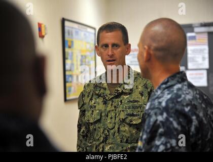 MARINE CORPS BASE HAWAII (July 11, 2018) — Rear Adm. John Okon, Commander, Naval Meteorology and Oceanography (METOC) Command, speaks with Lt. Christopher Wilson, Commander, Task Force 172 staff METOC officer, during a tour of Tactical Operations Center, Marine Corps Base Hawaii during Rim of the Pacific (RIMPAC) exercise, July 11. Twenty-five nations, 49 ships, six submarines, about 200 aircraft, and 25,000 personnel are participating in RIMPAC from June 27 to Aug. 2 in and around the Hawaiian Islands and Southern California. The world’s largest international maritime exercise, RIMPAC provide Stock Photo