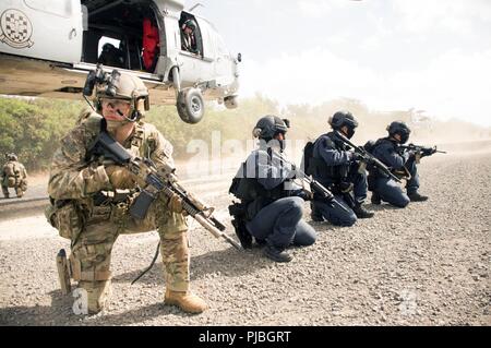 BELLOWS AIR FORCE STATION, Hawaii (July 5, 2018) A Soldier from the U.S. Army's 1st Battalion, 1st Special Forces Group (ABN) and multinational Special Operations Forces (SOF) disembarks from an MH-60S helicopter to take up fighting positions during with multinational partners during the Rim of the Pacific (RIMPAC) exercise, July 5. Twenty-five nations, 46 ships, five submarines, about 200 aircraft and 25,000 personnel are participating in RIMPAC from June 27 to Aug. 2 in and around the Hawaiian Islands and Southern California. The world’s largest international maritime exercise, RIMPAC provid Stock Photo