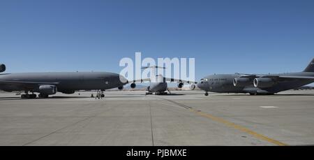 A U.S. Air Force KC-10 Extender, C-5 M Super Galaxy and a C-17 Globemaster III are parked on the ramp during the 60th Air Mobility Wing Change of Command Ceremony at Travis Air Force Base, Calif., July 10, 2018. Col. John Klein relinquished command of Air Mobility Command's largest wing to Col. Ethan Griffin. Stock Photo
