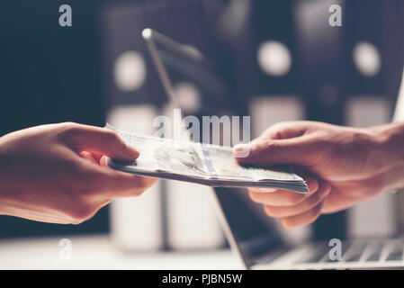 Close-up Of Person Hand Giving Money To Other Hand Stock Photo