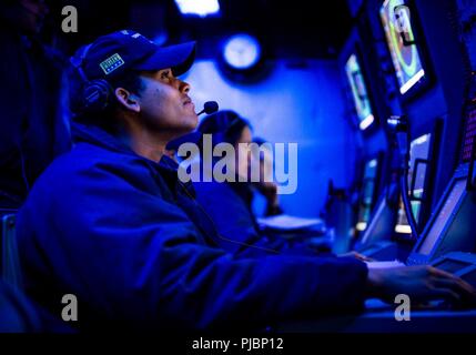 OCEAN (July 12, 2018) – Sonar Technician (Surface) 3rd Class Marcus Smith, from Chicago, mans a fire control console during an undersea warfare scenario aboard the guided-missile destroyer USS Dewey (DDG 105). Dewey is underway participating in the Rim of the Pacific (RIMPAC) exercise. Twenty-five nations, 46 ships, five submarines, about 200 aircraft, and 25,000 personnel are participating in RIMPAC from June 27 to Aug. 2 in and around the Hawaiian Islands and Southern California. The world's largest international maritime exercise, RIMPAC provides a unique training opportunity while fosterin Stock Photo