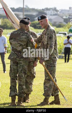 TORII STATION, OKINAWA, Japan – Maj. Gen. James F. Pasquarette passes the units flag to Col. Theodore O. White during the 10th Support Group (Regional) Change of command ceremony July 13 on Torii Station, Okinawa, Japan. Maj. Gen. Pasquarette is the U.S. Army Pacific Chief of Staff. Col. Theodore O. White relieved Col. Derek K. Jansen as commanding officer of 10th SG(R). Jansen was the commanding officer for two years. Stock Photo